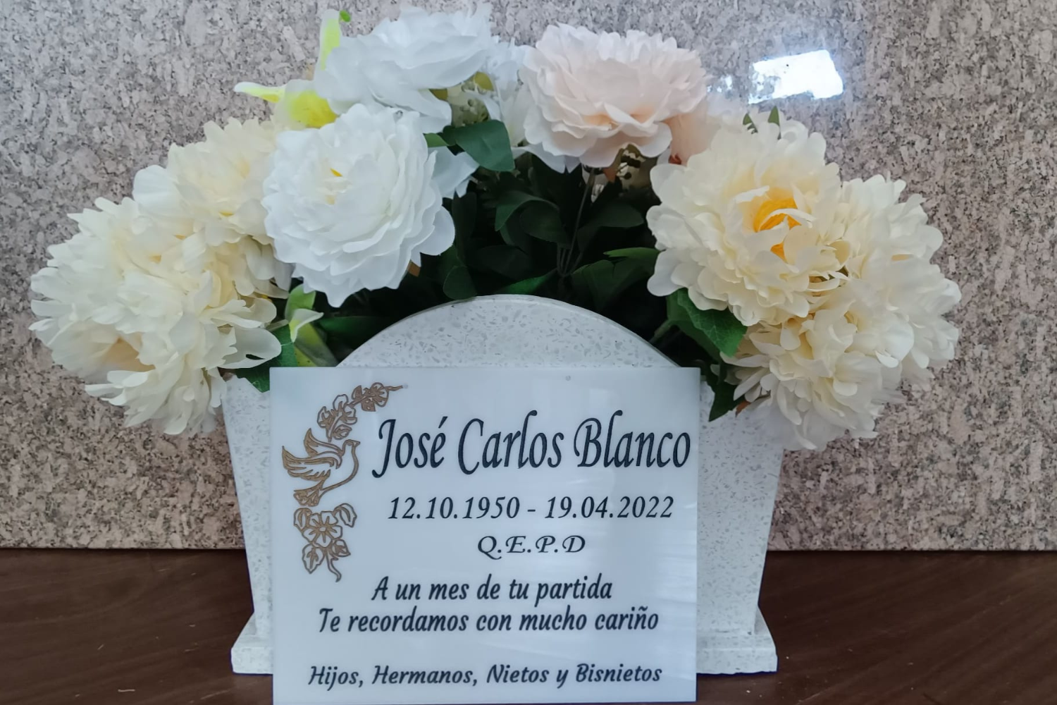 Lápida de mármol blanco con florero y arreglo floral